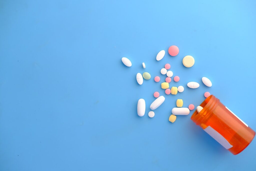 A pharmacist assists a customer at a pharmacy counter, discussing prescription options.