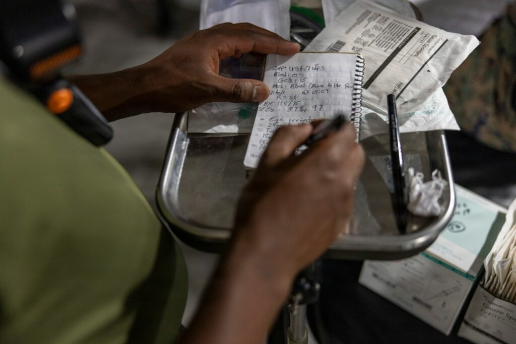 Person comparing a pharmacy receipt, prescription bottle, and insurance statement at a kitchen table.