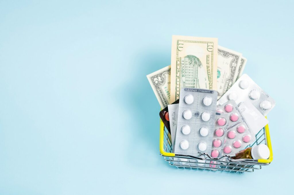 A patient compares prescription bottles, insurance information, and pharmacy prices at a kitchen table.